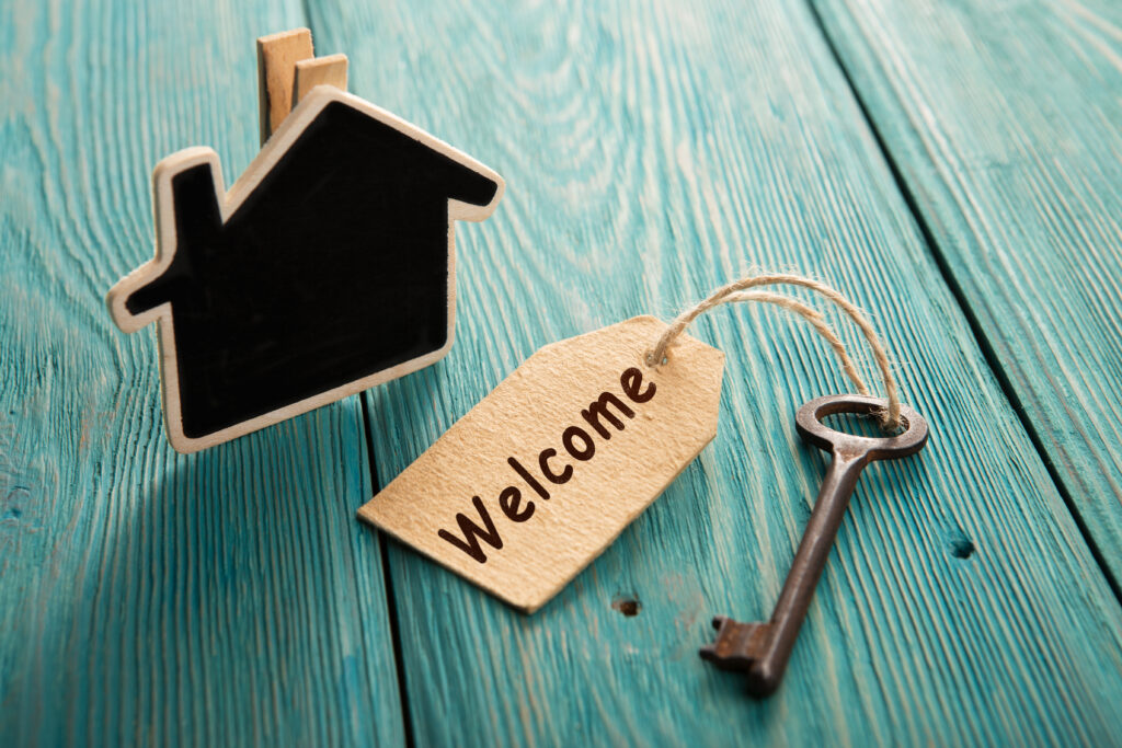 Vintage hotel key with welcome tag on the wooden background