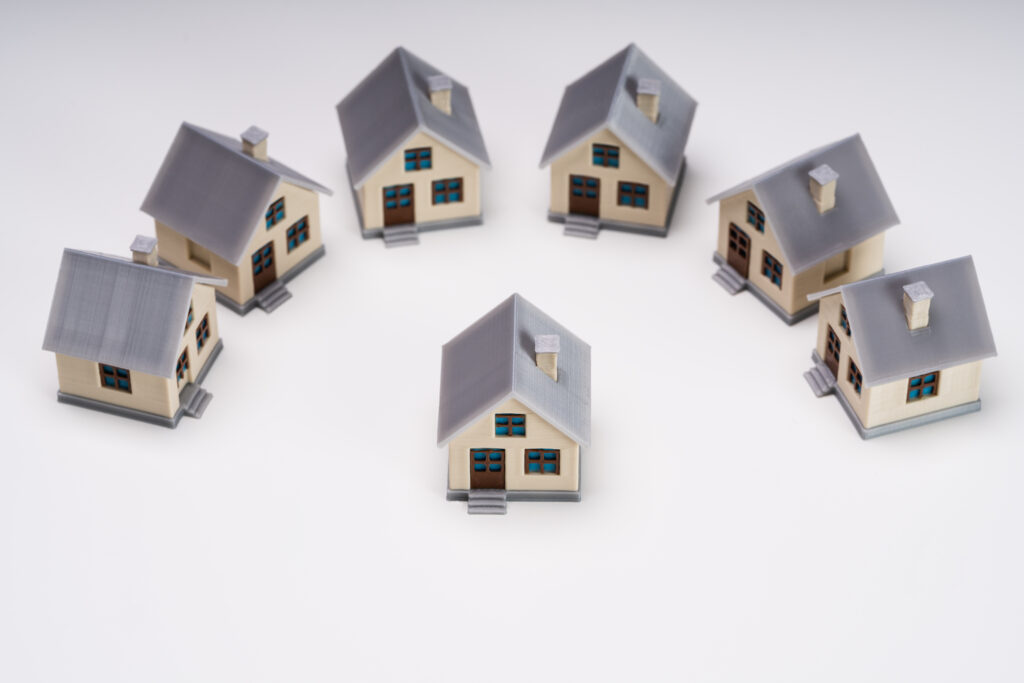 Miniature Houses Showing Standout Concept Isolated Over White Backdrop